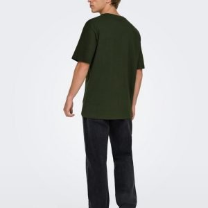 Back view of a man in a loose olive-green T-shirt, dark jeans, and white sneakers.