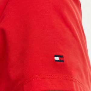 Close-up of a red short-sleeve shirt sleeve with a small Tommy Hilfiger flag logo near the hem.
