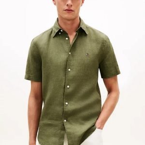Male model wearing an olive-green short-sleeve button-down shirt with a small chest logo on the left.