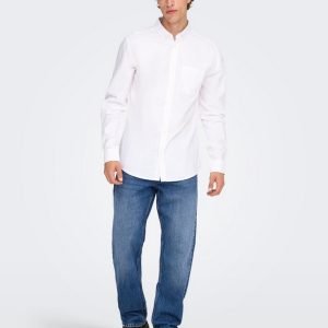 Man in a white button-down shirt, blue jeans, and black shoes posing casually.