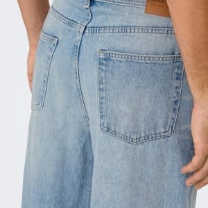 Back view of light-wash denim jeans showing two rear pockets and a leather brand patch at the waistband.