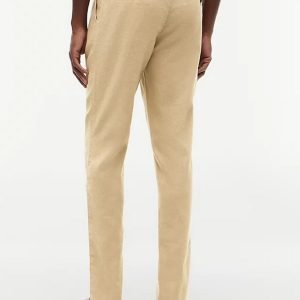 Back view of a man wearing beige chinos with two rear pockets and a belt, paired with tan sandals on a light background