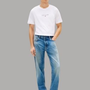 Model wearing a white short-sleeve T-shirt with light blue jeans and black loafers, standing against a gray background.