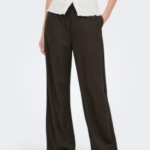 Person wearing black wide-leg pants with a drawstring waist and a white sleeveless button-front top; brown flats.