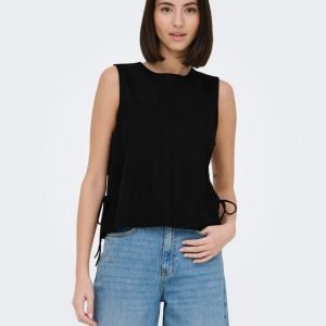 Model wearing a sleeveless black top with side ties paired with light-wash jeans, standing against a light gray background.