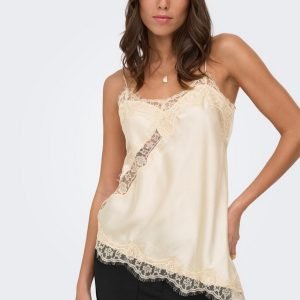 Model wearing ivory satin camisole with delicate lace trim at the neckline and hem.