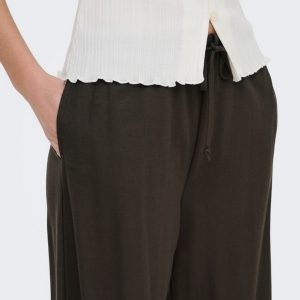 Person wearing a white ribbed top and dark brown drawstring pants with pockets, shown from waist to mid-thigh.