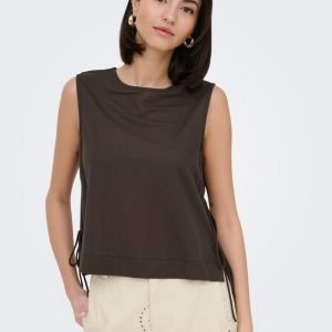 Female model wearing a sleeveless dark brown top with side ties and beige trousers in a studio setting.